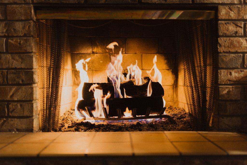 Several logs burn in a brick fireplace.