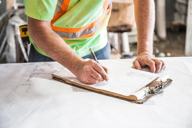 man writing on clipboard